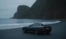 a silver bmw z4 parked near the ocean on a cloudy day