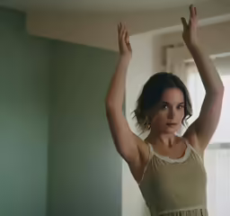a woman holds her arms behind her head