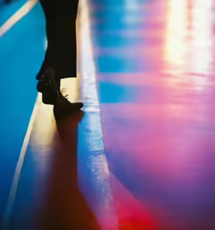 the legs and heels of a woman walking down a street