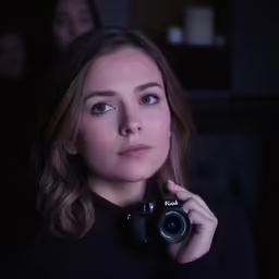 the woman is taking a photograph in the dark