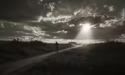 person walking up a road during a bright light