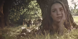 a young woman looking up with a group of people behind her