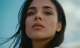 a woman with black hair looking up and to the side