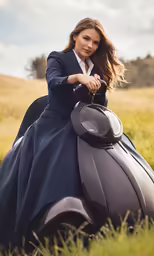 woman in blue dress leaning on car