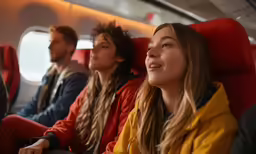 four people sitting on a plane looking in the air