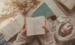 woman lying on bed with open book and sleeping mask