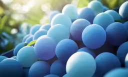 large bunches of blue and white candy in front of green leaves