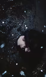 a woman covering her face with a black background