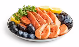 there is a plate of fish and different types of fruits on the table