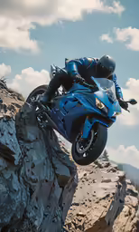 a man riding a blue motorcycle on top of a mountain