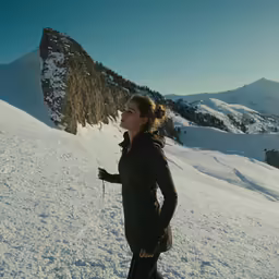 a woman is cross country skiing on a mountain slope