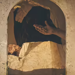 hand holding a baby in an old looking cave