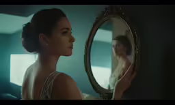a woman in a room is looking into the mirror