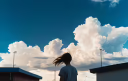 a young woman standing alone in front of a cloudy sky