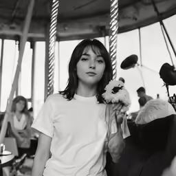 a girl on a carousel holding flowers and smiling