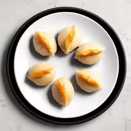 a plate filled with four scallops of sliced cheese