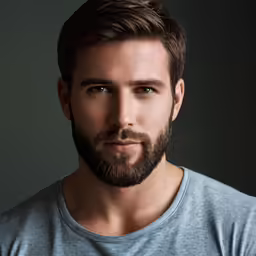 a bearded man with short hair is posing for the camera