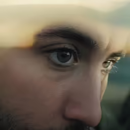 man with black jacket looking through window with brown eye