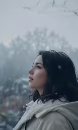 a woman standing in front of a tree covered in snow