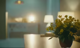 a close up of a flower vase on a table with lamps
