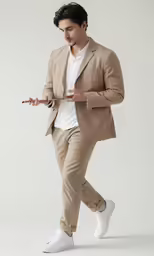 a man in beige suit with white sneakers on