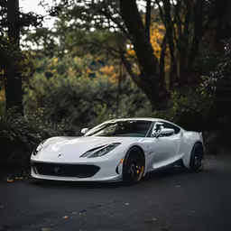a white sports car driving down a city street