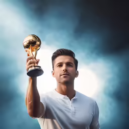 a man is holding up a trophy in the dark