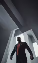 a man in a suit and red tie standing in a concrete area