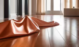 a piece of shiny leather laying on the floor