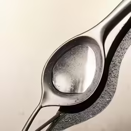 spoon closeup on silver spoon that is holding liquid
