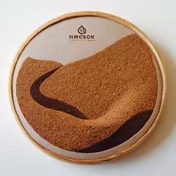 an embroidered item with a road going through the mountains