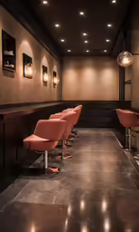 a dimly lit room with a bar with stools