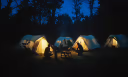 several people sitting around a table in a tent