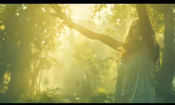 a woman standing in the woods holding onto some leaves