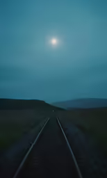 a full moon is setting over a road