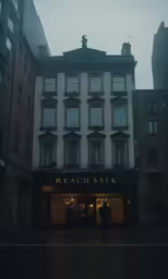 people are standing outside of the building in the rain