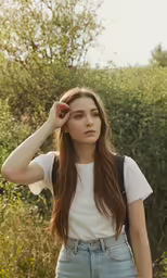 a woman with long brown hair in blue jeans and a t - shirt