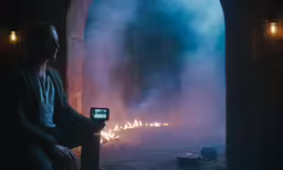 man sitting on chair watching a burning screen