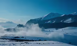 a landscape with mountains, snow and mist