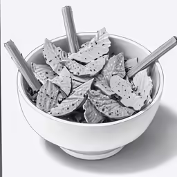 a bowl filled with silver metal sticks sitting next to leaves
