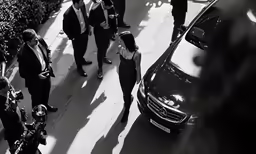 people are walking towards a car that is on the street
