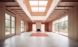 an empty room with many windows and a large rug