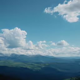 a view of some mountains and clouds in the sky