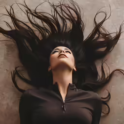 a woman with long hair is laying down