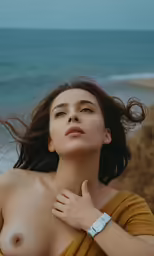 a naked woman sitting on a cliff near the ocean