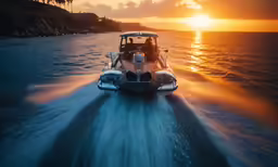 a boat riding through the ocean at sunset