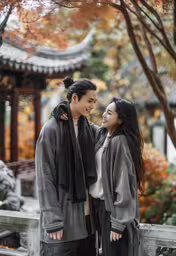 two people are smiling while standing together,a woman is holding the neck of a man