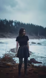 a girl in a dress standing on the beach