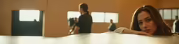 a girl looks over the edge of a table