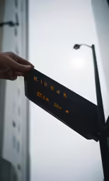 a hand holding a street sign displaying the direction to konark
